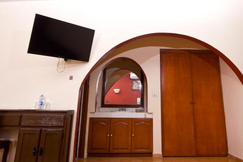 a kitchen with an arched doorway with a tv on the wall at Hotel & Motel Hacienda Jiutepec in Jiutepec