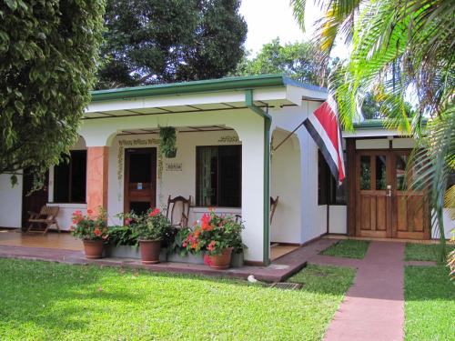a house with potted plants in front of it at Hotel La Rosa de America in Alajuela City
