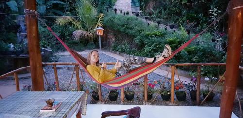 a woman laying in a hammock in a garden at Ella Secret Paradise in Ella