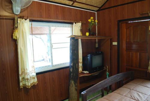 a bedroom with a window and a bed and a television at Prue Sa Raj in Phetchabun