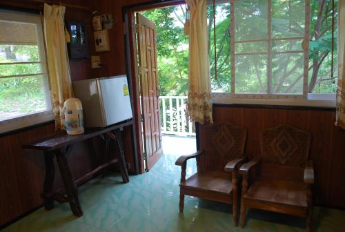 a living room with a chair and a refrigerator at Prue Sa Raj in Phetchabun