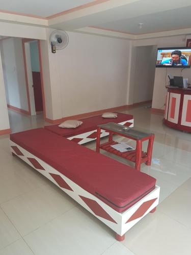 a large bed in a room with a tv at Catalina`s Inn family room in Panglao