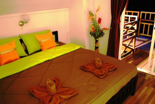 a bedroom with a bed with two flowers on it at Prue Sa Raj in Phetchabun