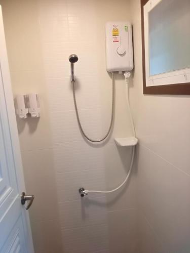 a bathroom with a shower with a hand dryer on the wall at Prue Sa Raj in Phetchabun