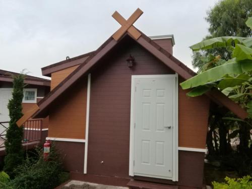 a small church with a cross on the roof at Prue Sa Raj in Phetchabun