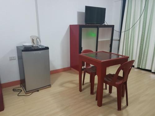 a room with a table and chairs and a television at Catalina`s Inn family room in Panglao
