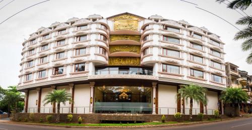 a large white building with a clock on it at Hotel Grace Majestic in Madgaon