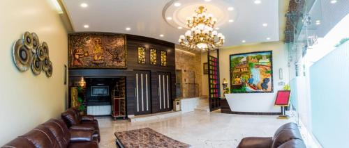 a living room with a couch and a chandelier at Hotel Grace Majestic in Madgaon