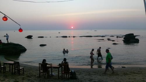 a group of people on the beach at sunset at Free Beach Resort in Phu Quoc
