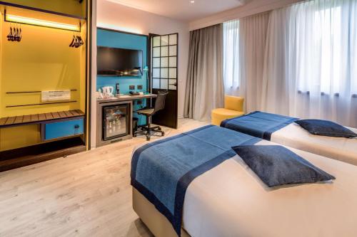 ein Hotelzimmer mit 2 Betten und einem Schreibtisch in der Unterkunft Best Western Hotel Cristallo in Rovigo