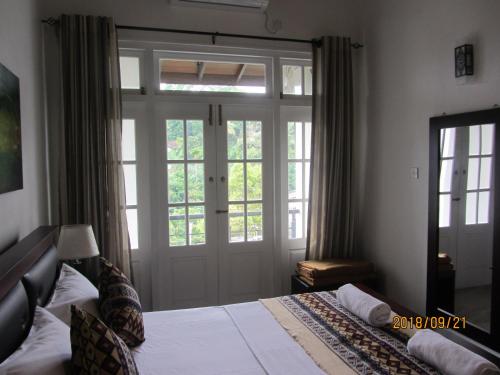 a bedroom with a bed and a large glass door at Twin Villa 22 in Katugastota