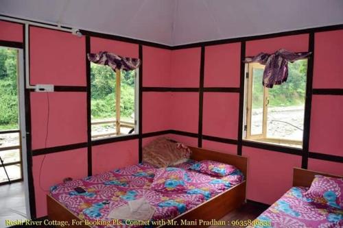 a bedroom with pink walls and a bed and two windows at Vamoosetrail Reshi River Cottage in Pedong