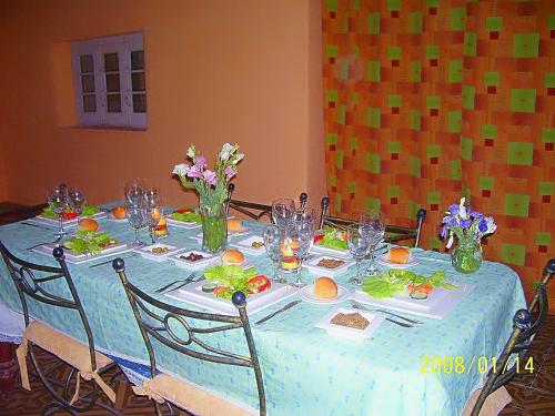 a table with a blue table cloth and flowers on it at Posada Doña Emilia Amarfil in Albardón