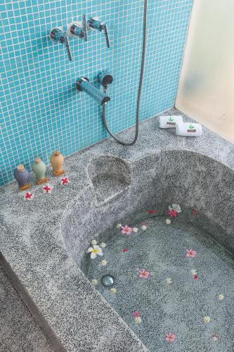 a bathroom with a tub with flowers in it at Mekong Riverside Boutique Resort & Spa in Cái Bè