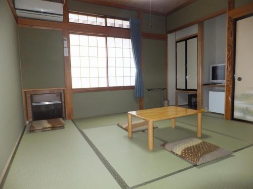 a living room with a table in the middle at Minshuku Iwatakan in Takayama