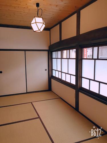 an empty room with windows and a light fixture at Akitsuki Kominka Yado You in Asakura