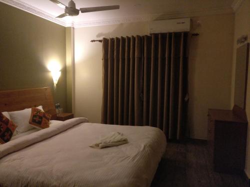 a hotel room with a bed with a robe on it at Hotel hornbill in Sauraha