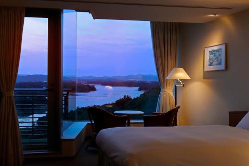 a hotel room with a large window with a view at Miyako Resort Okushima Aqua Forest in Shima