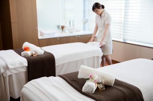 a woman standing in a hospital room with two beds at Miyako Resort Okushima Aqua Forest in Shima