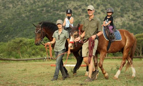 a group of people riding on a horse with a man at Pakamisa Private Game Reserve in Pongola