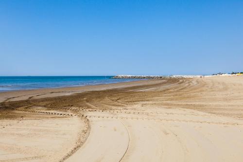 an empty beach with tire tracks in the sand at Camping Klaus in Cavallino-Treporti