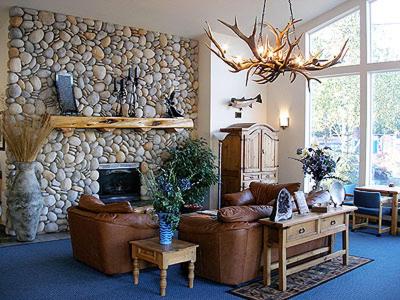 a living room with a couch and a stone wall at Edgewater Inn Shady Cove in Shady Cove