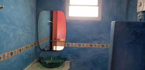 a blue bathroom with a mirror and a sink at Phuttharaksa Resort in Ko Larn