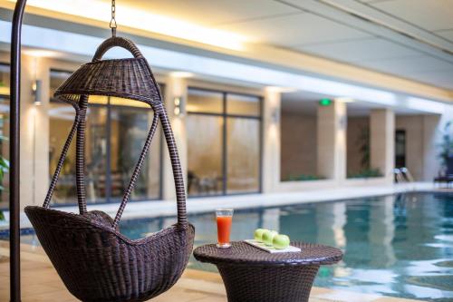 una piscina de hotel con dos cestas de mimbre y una bebida en Citadines Zhuankou Wuhan, en Wuhan