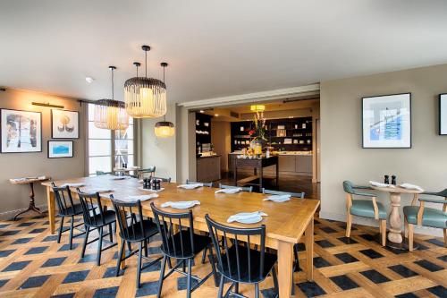 a dining room with a large wooden table and chairs at Mondrian Suites Berlin am Checkpoint Charlie in Berlin