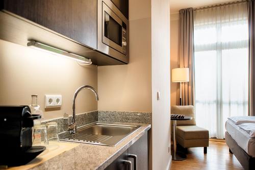 a kitchen with a sink and a bed in a room at Mondrian Suites Berlin am Checkpoint Charlie in Berlin
