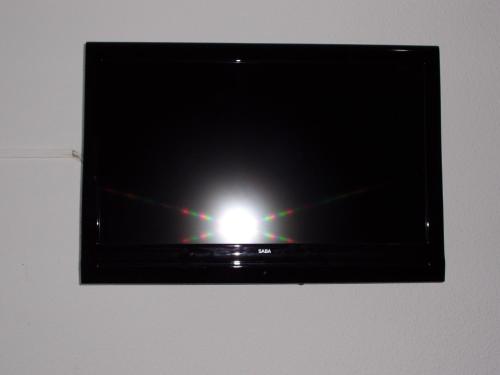 a flat screen tv with a light on it at Hostal Lima in Valladolid