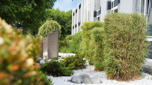 a garden with plants in front of a building at Hotel Olivier in Luxembourg
