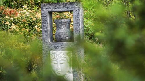 a statue of a vase sitting in a garden at Hotel Olivier in Luxembourg