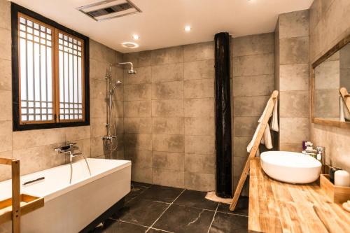 a bathroom with a tub and a sink at Dali Shaxi Qing Jing Courtyard in Jianchuan