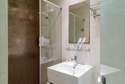 a bathroom with a sink and a shower and a mirror at Shihlin Metro Home in Taipei