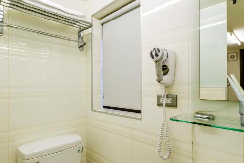 a bathroom with a toilet and a blow dryer at Shihlin Metro Home in Taipei