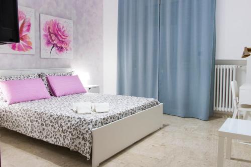 a bedroom with a bed with pink pillows at Tanzi Home in Bari