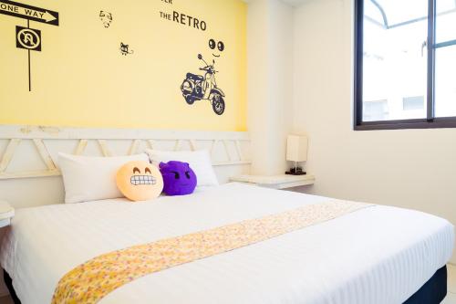 a bedroom with a white bed with a motorcycle on the wall at 安平72號民宿 in Tainan