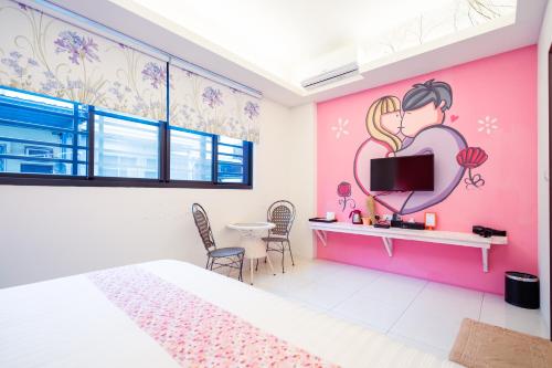 a bedroom with a pink wall with a girl and a mirror at 安平72號民宿 in Tainan
