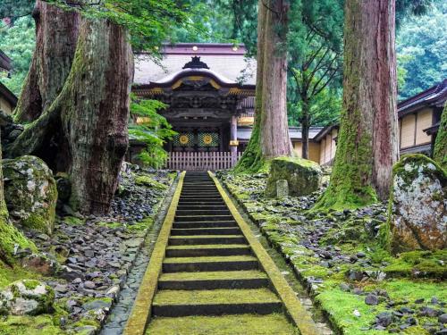 a garden with stairs leading to a temple at Awara Onsen Minoya Taiheikaku in Awara