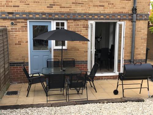 a table and chairs with an umbrella on a patio at Eastbourne, Sovereign Harbour Holiday Home in Eastbourne