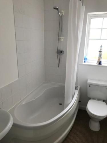 baño blanco con bañera y aseo en Eastbourne, Sovereign Harbour Holiday Home en Eastbourne