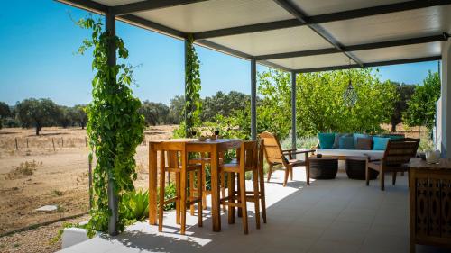 a patio with a table and chairs and a couch at Herdade dos Alfanges "THE BARN" in Viana do Alentejo