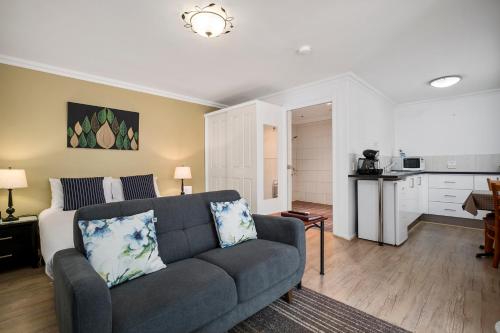 a living room with a couch and a kitchen at Oyster Cove Chalet in Kettering