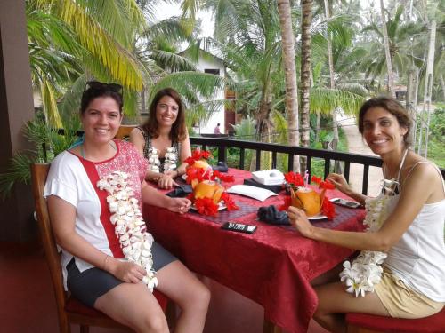 a group of three people sitting at a table at Sri Lancashire Guest House in Bentota