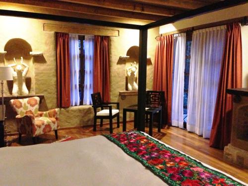 a bedroom with a bed and a living room at Guayaba Inn Boutique Hotel in San Cristóbal de Las Casas