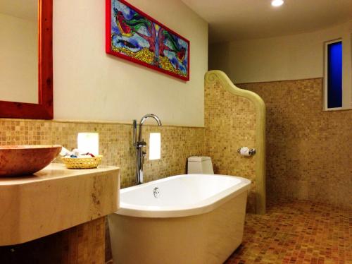 a bathroom with a bath tub and a sink at Guayaba Inn Boutique Hotel in San Cristóbal de Las Casas