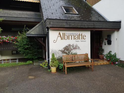 Menzenschwand-HinterdorfにあるB4 Albmatte-FEWO Sauna, Hallenbad Außenbecken Massagen nebenanのベンチ付き建物側の看板