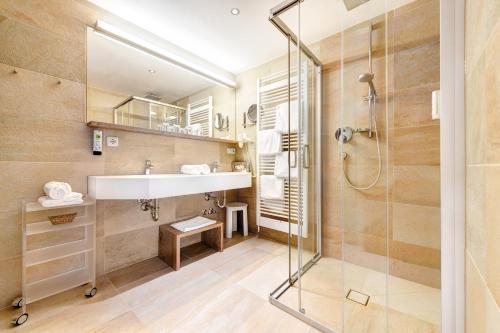 a bathroom with a sink and a shower at Alpenresort Walsertal in Damuls