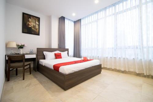 a bedroom with a bed and a desk and a window at AHA Residence Dien Bien Phu near Hang Xanh Binh Thanh in Ho Chi Minh City